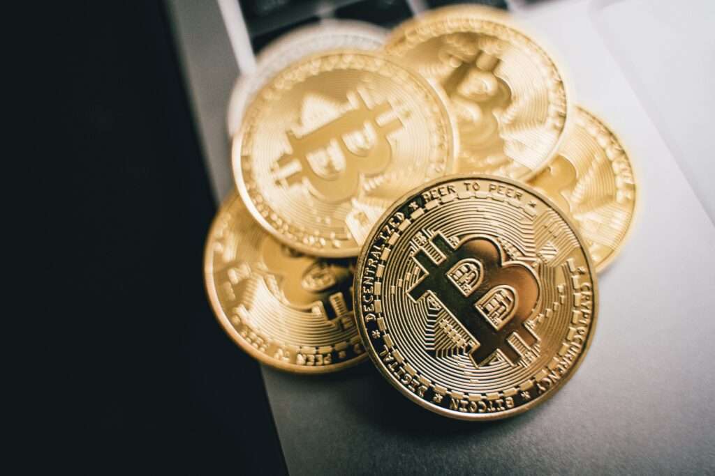 Close-up of golden Bitcoin coins on a laptop keyboard, symbolizing cryptocurrency investment.